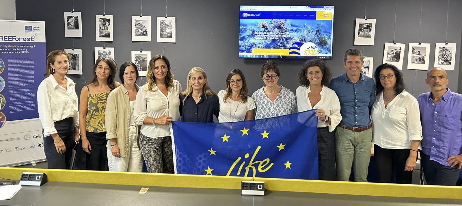 Our team during the midterm monitoring visit with the LIFE banner