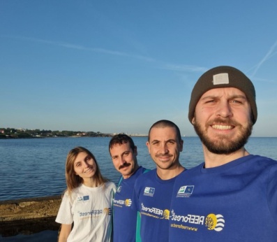 Part of our team smiling in front of the sea
